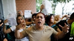 Una partidaria del gobierno discute con observadores electorales de la oposición a quienes se les negó el acceso al centro de votación de la Escuela Andrés Bello durante las elecciones presidenciales en Caracas, Venezuela. (AP/Cristian Hernandez)