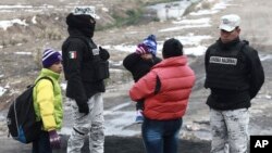 Una familia de migrantes cubanos es aprehendida por la Guardia Nacional mexicana antes de cruzar el Río Bravo, en la frontera con EEUU, en Ciudad Juárez. (AP/Christian Chavez)