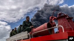 Bomberos se desplazan hacia el lugar del incendio, en la base de supertanqueros de Matanzas. (AP/Ramon Espinosa)