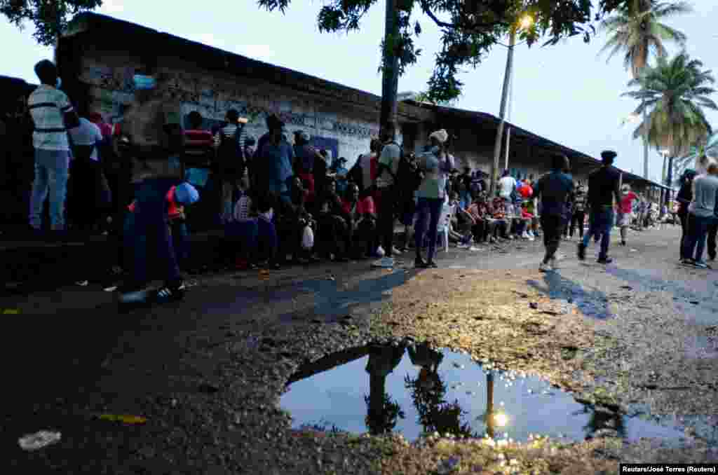 Migrantes de América Central, Haiti y Cuba esperan en las afueras de la Comisión de Asistencia para Refugiados Mexicana (COMAR), por sus siglas en inglés, para aplicar para asilo y estado de refugiado en Tapachula, México el 6 de mayo del 2021.