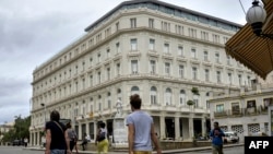 Turistas caminan hacia el Hotel Kempinski.