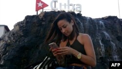 Una cubana chequea internet en su teléfono móvil en una calle de La Habana. 