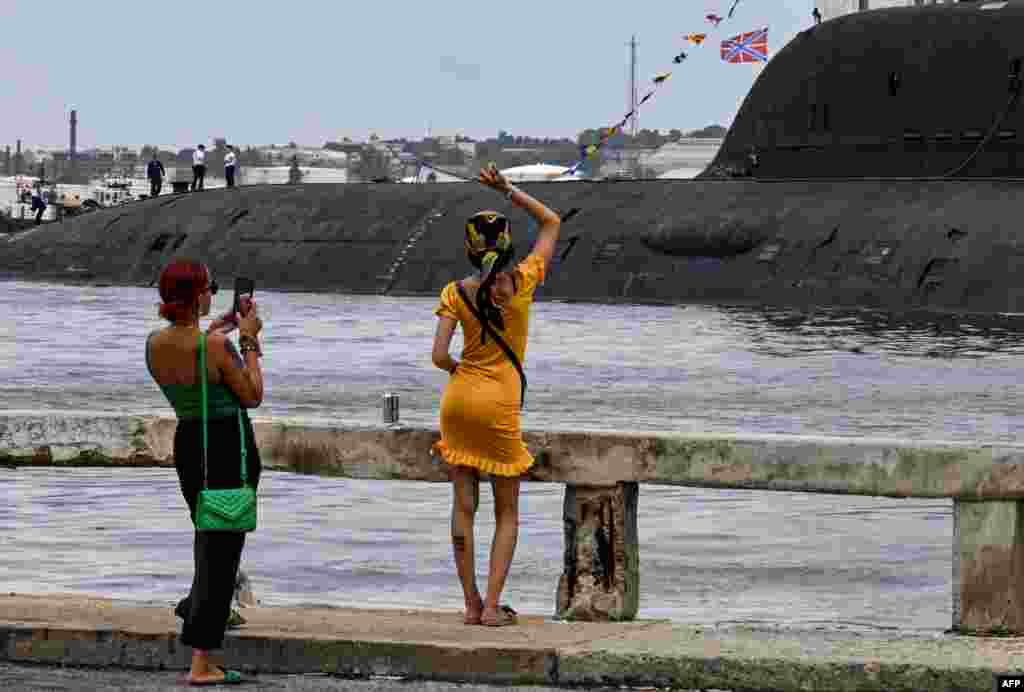 Una mujer saluda a los miembros de la tripulación del submarino de propulsión nuclear Kazán, parte del destacamento naval ruso que visita Cuba, después de su llegada al puerto de La Habana el 12 de junio de 2024.&nbsp;YAMIL LAGE / AFP