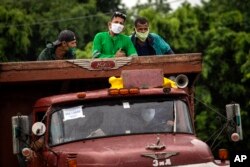 Un camión de la era soviética transporta a trabajadores. AP Photo/Ramon Espinosa