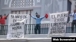 Opositores enarbolan carteles en contra del Gobierno cubano en la catedral de Santiago de Cuba.