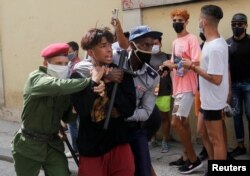 Policías vestidos de civil detienen a una persona durante protestas el 11 de julio de 2021. REUTERS / Stringer