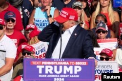 El ex presidente Donald Trump reacciona cuando se escuchan múltiples disparos durante un mitin de campaña en Butler, Pensilvania, el 13 de julio de 2024. REUTERS/Brendan McDermid