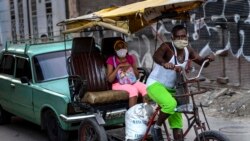 Usando máscara de protección contra el coronavirus, un hombre trasporta a clientes en un bicitaxi en La Habana. (AP/Ramon Espinosa)