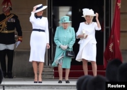 La primera dama Melania Trump asiste a una ceremonia con la reina Isabel II y Camilla, duquesa de Cornwall, en el Palacio de Buckingham.