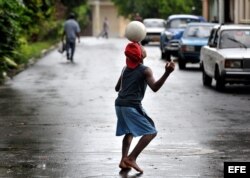 Un niño cubano muestra sus habilidades con un balón de fútbol.