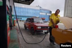 Un taxista que no quiso ser identificado llena su tanque de gasolina en La Habana, Cuba, el 11 de diciembre de 2023. REUTERS/Alexandre Meneghini