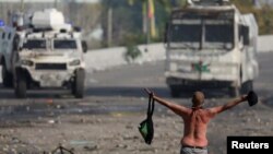 Un manifestante frente a las tanquetas de la guardia nacional durante las protestas de 2019 en Caracas. (Manaure Quintero / Reuters).