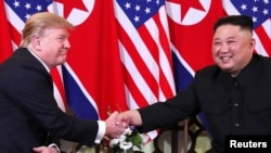 Donald Trump y Kim Jong Un, se saludan en Hanoi.