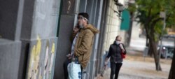 Un hombre habla por teléfono usando una pantalla para protegerse del COVID-19 en Buenos Aires, Argentina. Foto: ONU Argentina / Santiago Mele.