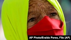 Una mujer participa en una protesta por el manejo gubernamental del COVID-19 en Brasilia, Brasil. AP Photo/Eraldo Peres