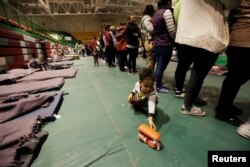 Un niño juega con un juguete mientras los migrantes de América Central hacen cola para comer en un refugio improvisado en Ciudad Juárez, México.