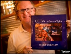 El fotógrafo Peter Turnley con su último libro publicado sobre Cuba.