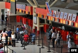 Varias personas hacen cola en el mostrador de la aerolínea Cubana de Aviación, en el aeropuerto José Martí, de La Habana (Cuba).