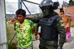 Un policía que actúa a las órdenes de oficiales que ya no responden al gobierno de Evo Morales arresta a un partidario del ex presidente durante una violenta protesta en La Paz (Foto: Ronaldo Schemidt/AFP).