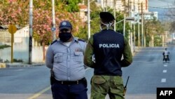 Oficiales de policía vigilan la entrada a un barrio del Vedado, en La Habana, cerrado por el coronavirus. 