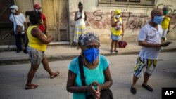 Personas con mascarillas rezan a la Virgen de la Caridad del Cobre. (AP Foto/Ramón Espinosa)