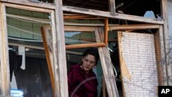 Una mujer en su apartamento de Kyiv tras un ataque ruso el 14 de marzo de 2022. (AP Photo/Efrem Lukatsky).