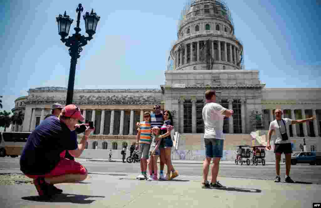 Turistas estadounidenses posan frente al Capitolio Nacional.