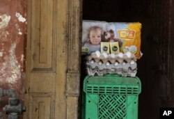 Huevos, cigarros y pañales se exhiben a la venta en la entrada de una casa, en La Habana, Cuba, el miércoles 13 de marzo de 2024. (Foto AP/Ariel Ley)