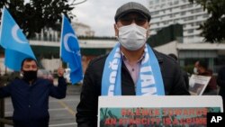 "Guardar silencio ante una atrocidad es un crimen", advierte un cartel de un activista uigur en Turquía, el 10 de febrero de 2021. (AP Photo/Mehmet Guzel)