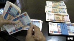 Una persona cuenta pesos cubanos convertibles.